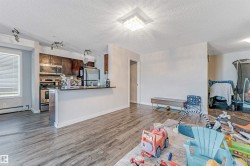 Open-concept living space featuring wood-finish flooring - 