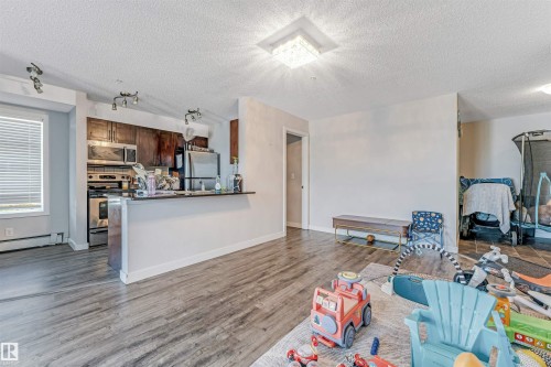 Open-concept living space featuring wood-finish flooring - 320 534 Watt Boulevard, Edmonton, AB - Indoor