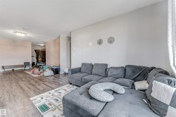 Open-concept interior featuring wood-finish flooring, light neutral wall paint, and recessed lighting - 