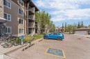 Multi-story building exterior featuring stone and horizontal siding accents, multiple balconies with dark railings, and a dedicated bicycle rack - 320 534 Watt Boulevard, Edmonton, AB  - Outdoor 
