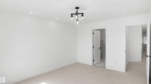 Carpeted room with recessed lighting and a contemporary chandelier - 803 30 Avenue, Edmonton, AB 