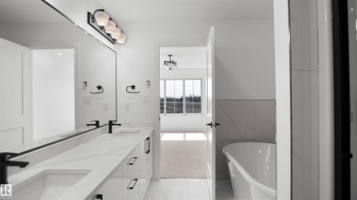 Dual vanity featuring matte black faucets, white countertops, and integrated sinks - 803 30 Avenue, Edmonton, AB 