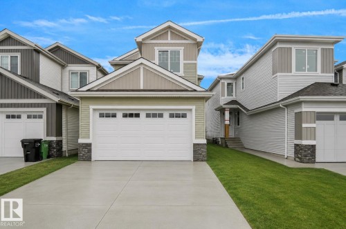 Contemporary exterior featuring light green siding and stone accents - 803 30 Avenue, Edmonton, AB 