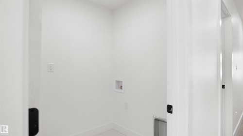 Dedicated laundry area featuring white walls, tile flooring, and essential utility hookups - 803 30 Avenue, Edmonton, AB 