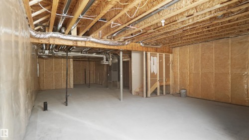 Unfinished lower level with exposed ceiling joists and ductwork, featuring a concrete floor, framed wall partitions, and insulation - 803 30 Avenue, Edmonton, AB 