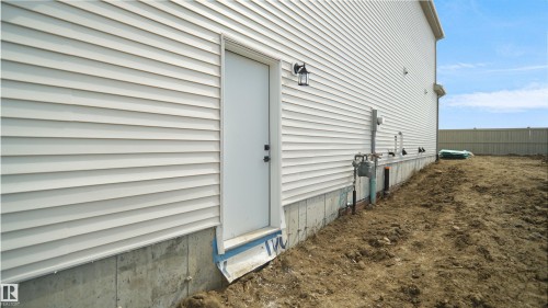 Exterior side elevation featuring white vinyl siding - 803 30 Avenue, Edmonton, AB 