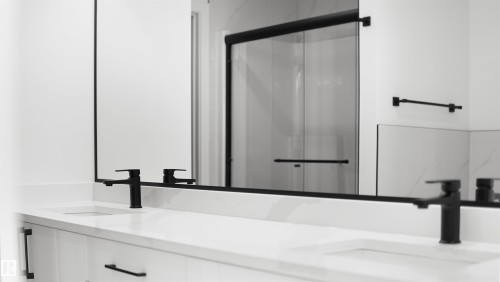 Dual vanity with integrated sinks and white countertops, featuring matte black faucets and hardware - 803 30 Avenue, Edmonton, AB 