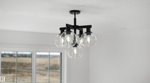 Black metal chandelier with five clear glass globes, exposed filament bulbs, and white trim windows - 803 30 Avenue, Edmonton, AB 