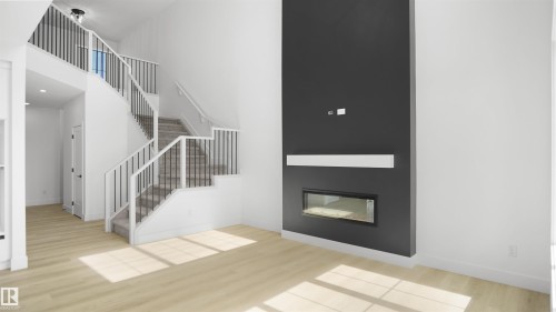 Sleek fireplace feature wall with a linear insert and light wood-finish flooring - 803 30 Avenue, Edmonton, AB 
