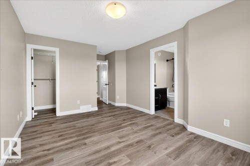 Spacious room featuring wood-finish flooring, neutral wall tones, and white baseboards - 62 Durrand Bend, Fort Saskatchewan, AB 