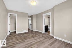 Spacious room featuring wood-finish flooring, neutral wall tones, and white baseboards - 
