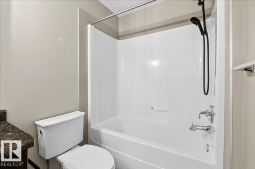 White fiberglass tub and shower combination with chrome fixtures and a matte black handheld showerhead - 62 Durrand Bend, Fort Saskatchewan, AB 