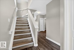 Staircase with wood-finish treads and white risers, featuring white handrails and painted walls - 