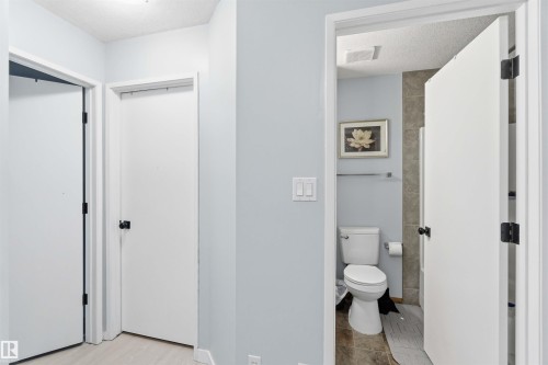 Hallway with light blue walls and wood-finish flooring - 8 15128 22 Street, Edmonton, AB 