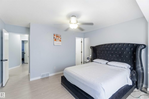 Light-toned wood-finish flooring throughout, complemented by a ceiling fan with integrated lighting - 8 15128 22 Street, Edmonton, AB 