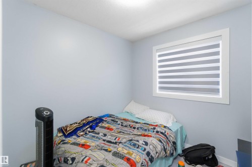 Pale blue wall finish with a white window frame and horizontal blinds - 8 15128 22 Street, Edmonton, AB 