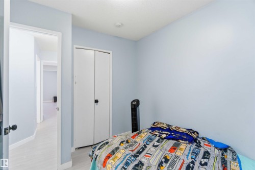Room featuring light blue walls, white trim, and light wood-finish flooring - 8 15128 22 Street, Edmonton, AB 