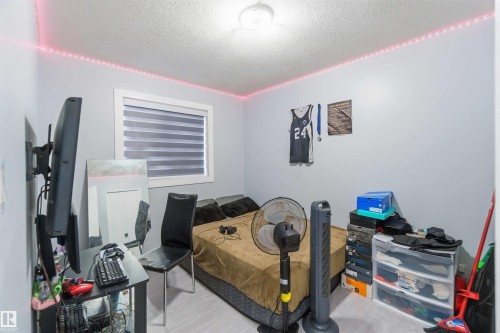 Neutral-toned room featuring a single window with blinds, light-colored walls, and a ceiling light fixture - 8 15128 22 Street, Edmonton, AB 