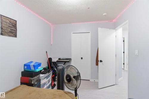 Interior room with light gray walls, white trim, and light wood-finish flooring - 8 15128 22 Street, Edmonton, AB 