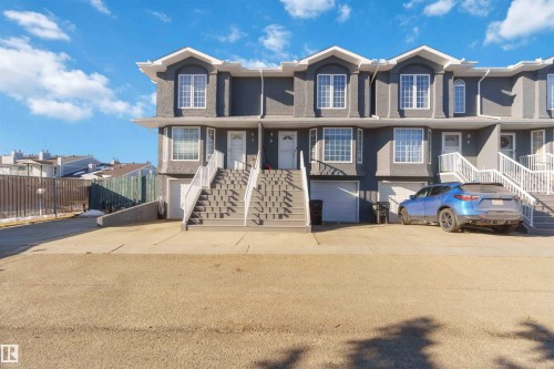 Contemporary townhome exterior featuring a stucco finish and contrasting white trim - 8 15128 22 Street, Edmonton, AB 