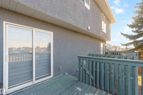 Private outdoor deck space featuring wood decking and a perimeter railing - 8 15128 22 Street, Edmonton, AB 