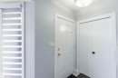 Entryway featuring a white paneled door with an arched transom window, brass hardware, and an overhead flush-mount light fixture - 8 15128 22 Street, Edmonton, AB 