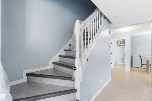 Light wood-finish flooring extending from the entryway - 8 15128 22 Street, Edmonton, AB 