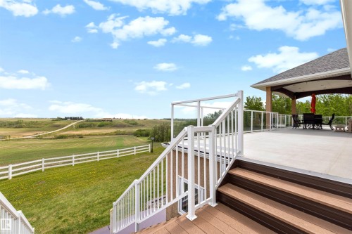 Spacious outdoor deck featuring light-colored surfacing and a covered patio area - 28125 Highway 587, Rural Red Deer County, AB 