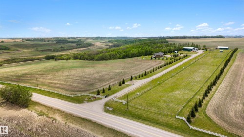 Expansive rural property featuring a main residence, multiple outbuildings, a paved driveway, and established tree lines - 28125 Highway 587, Rural Red Deer County, AB 