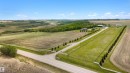 Expansive rural property featuring a main residence, multiple outbuildings, a paved driveway, and established tree lines - 28125 Highway 587, Rural Red Deer County, AB 