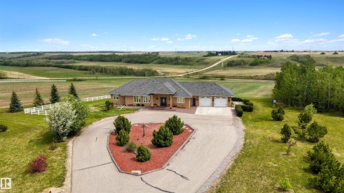 Expansive property featuring a single-story residence, attached three-car garage, and a paved circular driveway - 28125 Highway 587, Rural Red Deer County, AB 