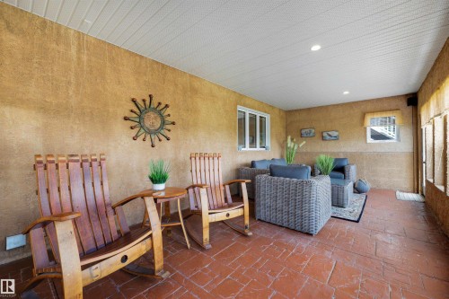 Screened porch featuring textured walls, a white slatted ceiling with recessed lighting, and stamped concrete flooring - 28125 Highway 587, Rural Red Deer County, AB 