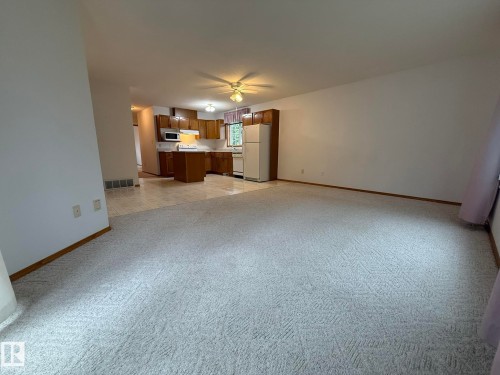 Spacious room featuring light-toned carpet flooring and white walls - 102 4610 50 Avenue, Stony Plain, AB 