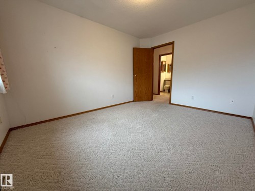 Spacious room featuring neutral carpet flooring and white painted walls - 102 4610 50 Avenue, Stony Plain, AB 