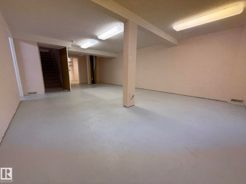 Spacious lower level featuring light-colored flooring, recessed lighting fixtures, and exposed ceiling beams - 102 4610 50 Avenue, Stony Plain, AB 