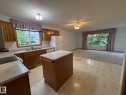 Open concept kitchen and living area featuring a kitchen island, recessed lighting, and a ceiling fan - 102 4610 50 Avenue, Stony Plain, AB 