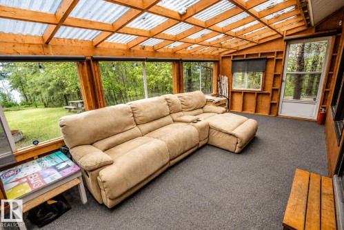 Enclosed sunroom with wood-frame construction and a transparent corrugated roof - 61 Stang Cres, Rural Two Hills County, AB 