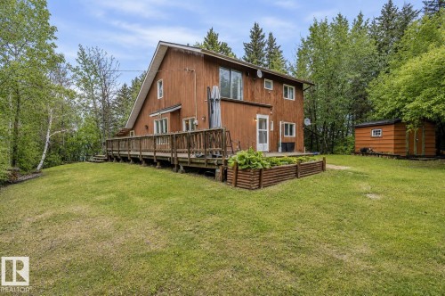 Wood-sided residence featuring a multi-level deck, a pitched roofline, and a garden bed - 61 Stang Cres, Rural Two Hills County, AB 