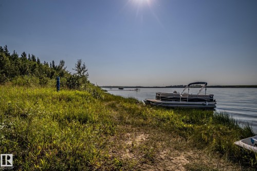 Lush green shoreline featuring a tranquil body of water - 61 Stang Cres, Rural Two Hills County, AB - Outdoor With Body Of Water With View