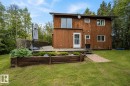 Wood-sided exterior featuring multiple windows and a sliding glass door - 61 Stang Cres, Rural Two Hills County, AB 