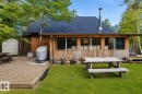 Rear exterior featuring a dark-shingled roof and wood siding - 61 Stang Cres, Rural Two Hills County, AB 