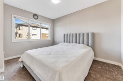 Bedroom featuring a large window, neutral wall paint, and brown carpet flooring - 