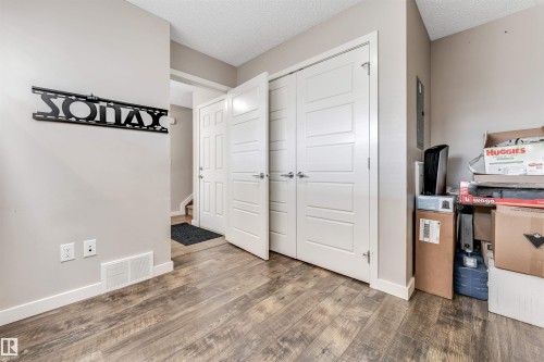 Wood-finish flooring throughout, complemented by light-toned wall paint and white baseboards - 1624 33A Street, Edmonton, AB 