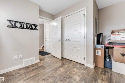 Wood-finish flooring throughout, complemented by light-toned wall paint and white baseboards - 