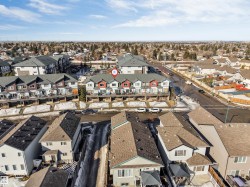 Townhome row featuring a pitched roofline, red and white exterior siding, and individual balconies - 