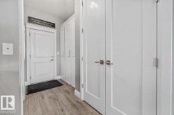 Back entryway off the kitchen, leading to the garage. Built-in pantry storage behind the white double doors. - 