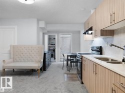 Functional kitchen featuring wood-finish cabinetry, light-toned countertops, and a stainless steel sink with a pull-down faucet - 
