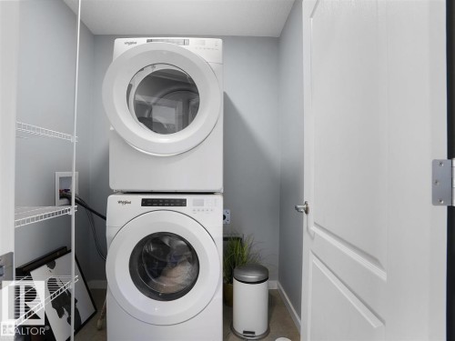Dedicated laundry closet featuring a stacked washer and dryer, white wire shelving, and light gray wall paint - 207 41 Avenue, Edmonton, AB 