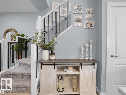 Carpeted staircase with white risers and modern black iron balusters - 207 41 Avenue, Edmonton, AB 