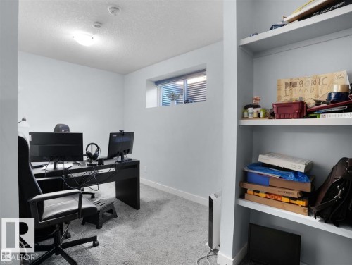 Dedicated workspace featuring light grey carpeting, white baseboards, and a semi-flush mount ceiling light - 207 41 Avenue, Edmonton, AB 